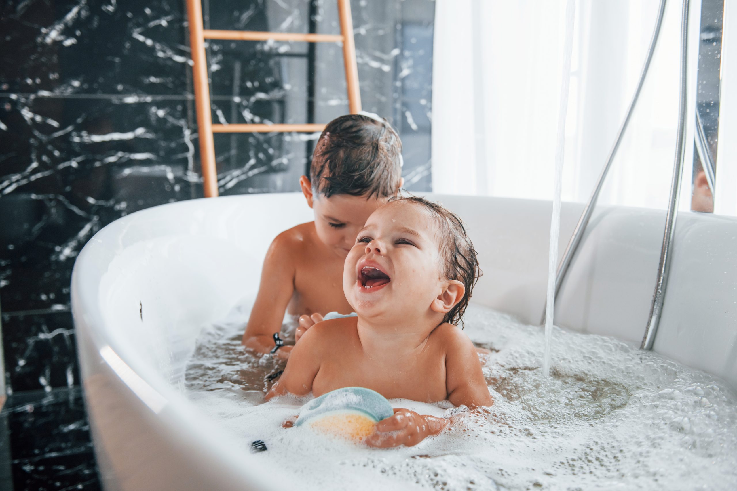 Zwei Kinder haben Spaß in der Badewanne